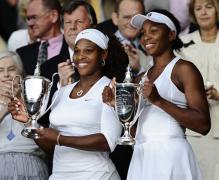 Serena Williams and Venus hold their doubles chamionship trophies in Wimbledon 2009.jpg