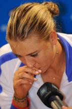 Maria Sharapova talks into the microphone in a white jacket.JPG
