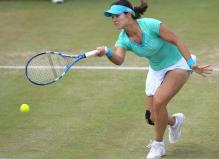 Li Na hits a top spin shot on a low ball on grass.JPG
