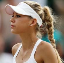 Anna Kournikova in a ponytail and white visor during Wimbledon 2010.JPG