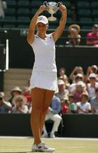 Kristyna Pliskova in white visor and tennis outfit holds her 2010 Wimbledon championship trophy.JPG