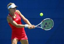 Maria Kirilenko in a red Adidas tennis dress hits a 2 handed backhand.JPG