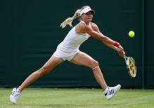 Maria Kirilenko lunges to hit a 2 handed backhand during Wimbledon 2010.JPG