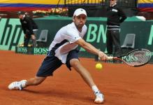 Mardy Fish slides on red clay to hit a defensive backhand slice.JPG