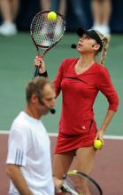 Anna Kournikova bounces a ball on her racquet in a red tennis outfit.JPG