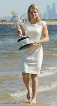 Kim Clijsters bare footed in white dress holding her 2011 Australian Open championship trophy at the beach.JPG