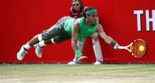 Rafael Nadal goes airborne to return a shot.jpg