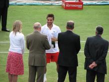 Arnaud Clement holds a bottle of wine.jpg