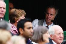 John McEnroe looks on from the press box.jpg