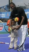 Donald Young helps a 3 year old tennis prodigy.jpg