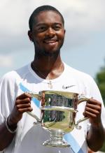 Donald Young holds up a silver trophy cup.jpg